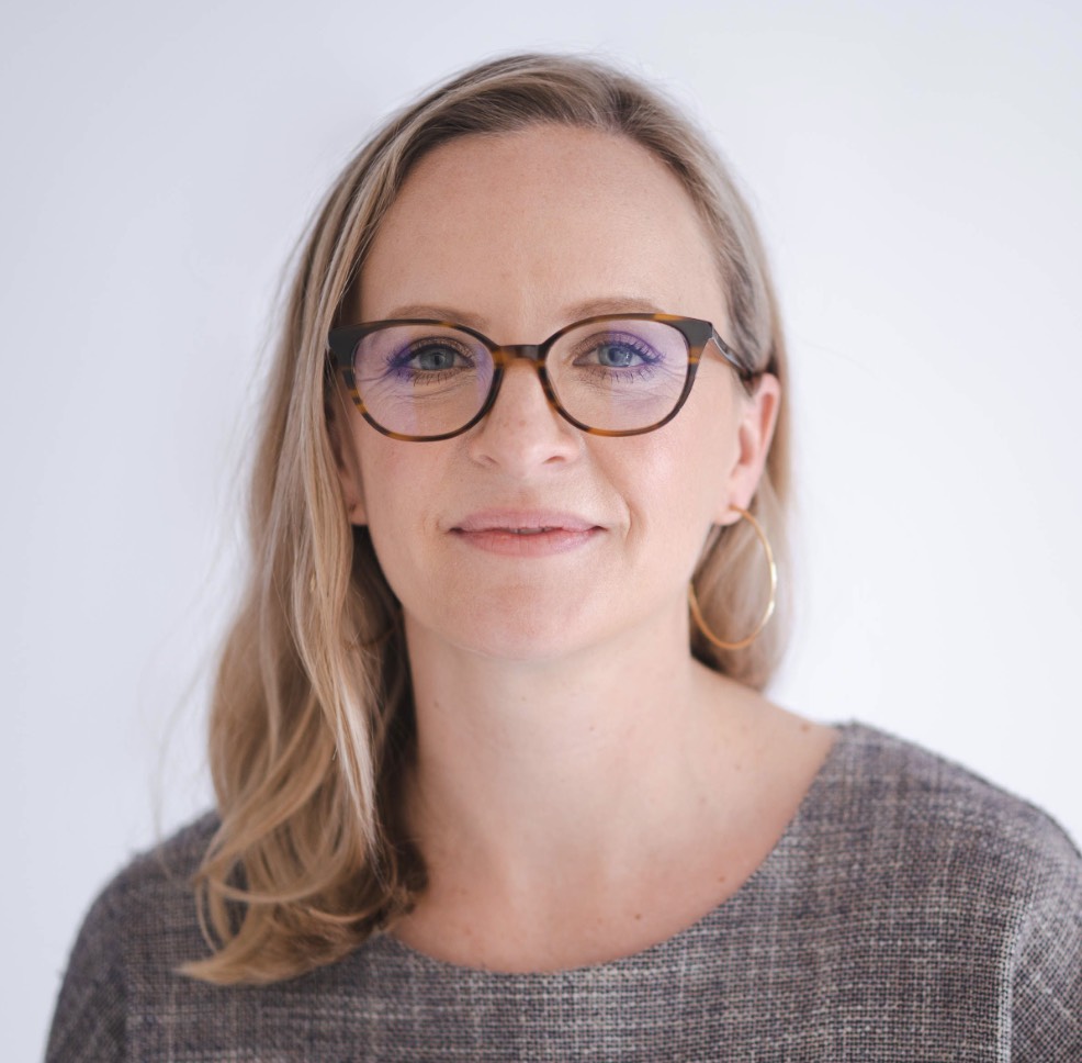 Photo of a white woman with blonde hair and glasses