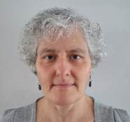 Photo of a white woman with green curly hair. 